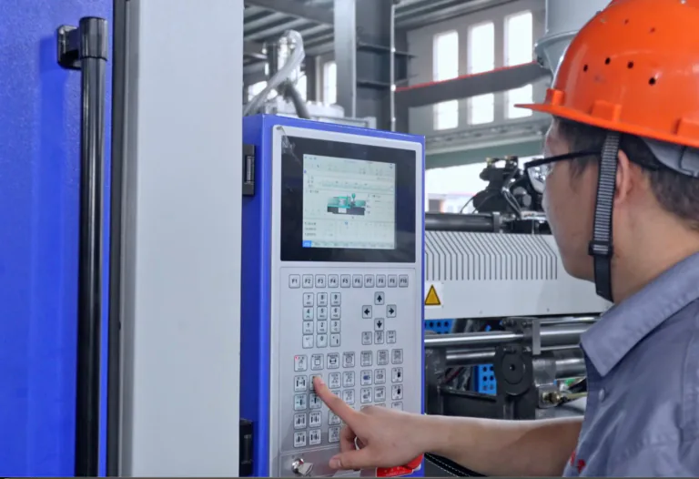 BEST Machine technician operating an injection molding machine control panel